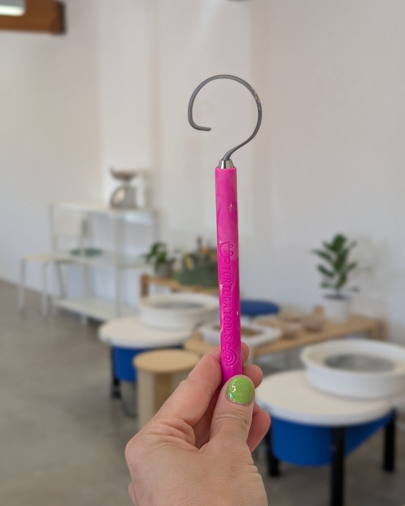 Pitaya hook tool held up in a bright pottery studio
