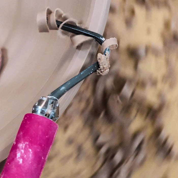 Pitaya loop tool mid-trim with a curl of clay in the loop